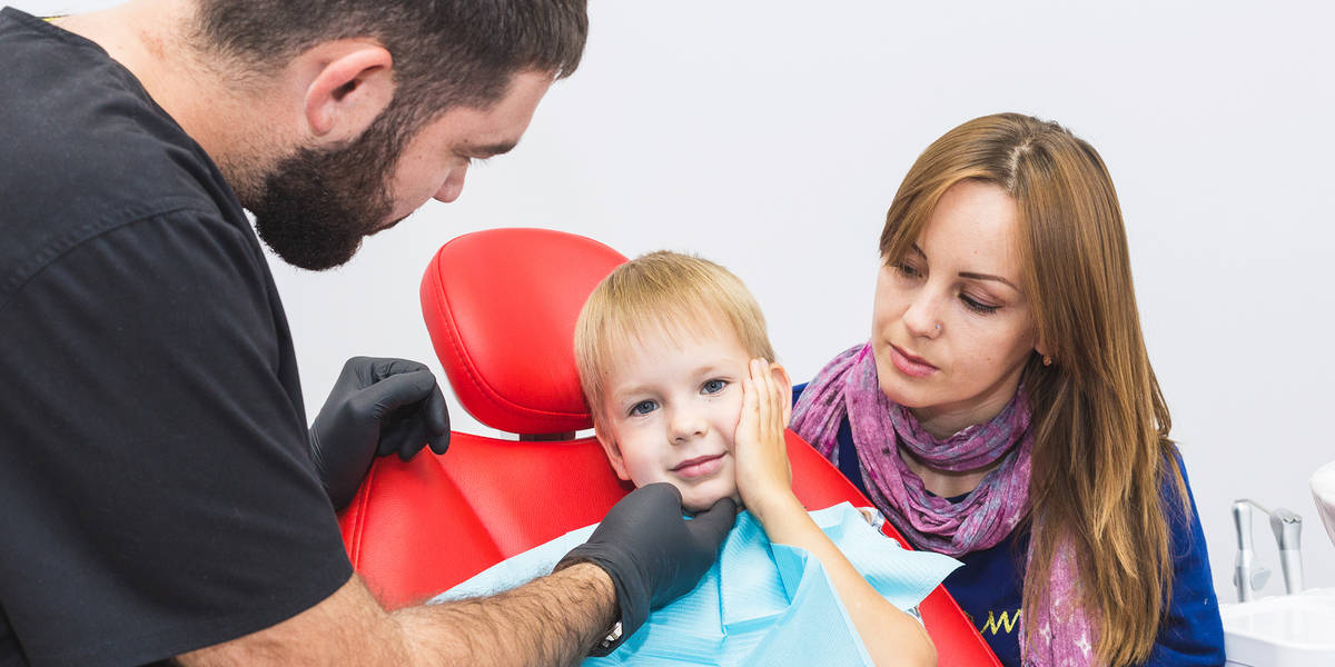 Dental clinic. Reception, examination of the patient. Teeth care. Dentist treating teeth of little boy in dentist office